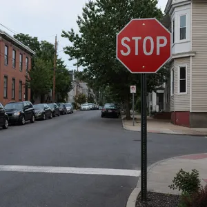 A red stop sign on a street corner displaying the word 