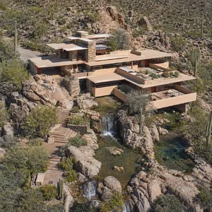 Aerial view of a modernist desert home, in the style of Frank Lloyd Wright's Fallingwater but adapted to desert conditions. Show integration with rocky landscape and water features. - OpenAI GPT Image 2
