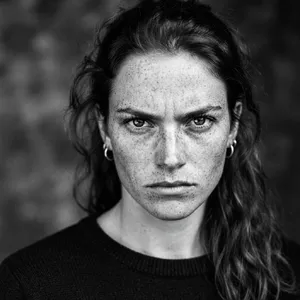 A black and white close-up portrait of a freckled woman with an intense gaze. - Google Nano Banana 2 Lite