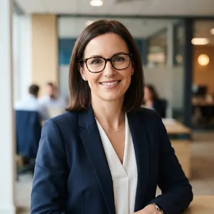 A professional headshot of a businesswoman wearing glasses, against a blurred background. - Google Nano Banana 2 Lite