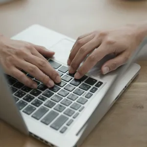 A person typing on a laptop keyboard, showing both hands on the keys. - Alibaba Z-Image Turbo