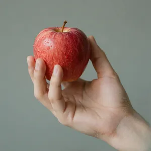 A realistic photo of a hand holding a red apple, with all fingers clearly visible. - Alibaba Z-Image Turbo