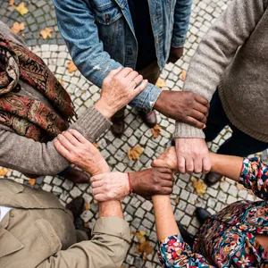 A group of five people joining hands in a circle, seen from above. - Google Nano Banana Pro