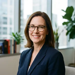 A professional headshot of a businesswoman wearing glasses, against a blurred background. - Google Nano Banana Pro