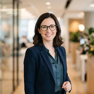 A professional headshot of a businesswoman wearing glasses, against a blurred background. - Google Nano Banana 2