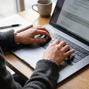 A person typing on a laptop keyboard, showing both hands on the keys. - Google Nano Banana 2.1