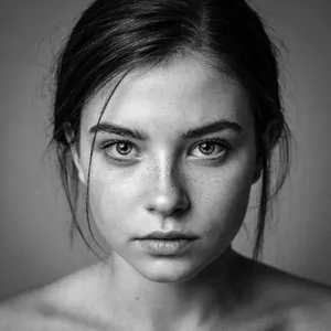 A black and white close-up portrait of a freckled woman with an intense gaze. - Ideogram Ideogram 4.0 (Quality)