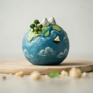 A dessert cake that looks like a tiny planet, complete with miniature trees and mountains, photographed in a professional food photography style with tilt-shift focus effect. - Ideogram Ideogram 4.0 (Quality)