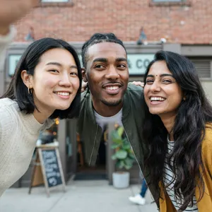A group selfie of three friends of different ethnic backgrounds smiling at the camera. - Ideogram Ideogram 4.0 (Quality)