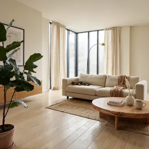 A photorealistic interior of a modern Scandinavian-style living room with natural light streaming through floor-to-ceiling windows. Show detailed wood textures, fabric materials, and proper light reflections. - Ideogram Ideogram 4.0 (Quality)