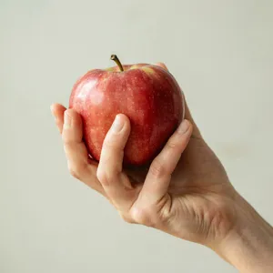 A realistic photo of a hand holding a red apple, with all fingers clearly visible. - Ideogram Ideogram 4.0 (Quality)