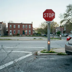 A red stop sign on a street corner displaying the word 