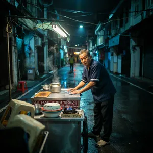 Rain-slicked Singapore street, 3 AM. A lone elderly hawker cleans his cart under one flickering fluorescent light. Steam rises gently. Low-angle shot, photorealistic - Ideogram Ideogram 4.0 (Quality)