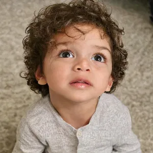 A hyper-realistic photo of a toddler with curly hair and big eyes, looking upward. - OpenAI GPT Image 2.5 Flare