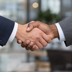 A close-up of two people shaking hands, both hands fully visible with five fingers each, in sharp focus against a blurred background. - OpenAI GPT Image 2.5 Sunburst