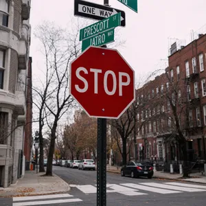 A red stop sign on a street corner displaying the word 