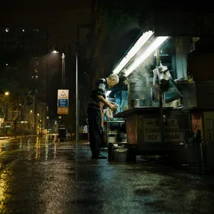 Rain-slicked Singapore street, 3 AM. A lone elderly hawker cleans his cart under one flickering fluorescent light. Steam rises gently. Low-angle shot, photorealistic - OpenAI GPT Image 2