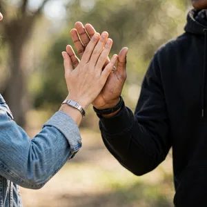 Two people high-fiving, with focus on their hands meeting mid-air. - Meta Muse Image