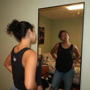 A person standing before a mirror, with their front and reflected back both visible. - XAI Grok Imagine (Quality)