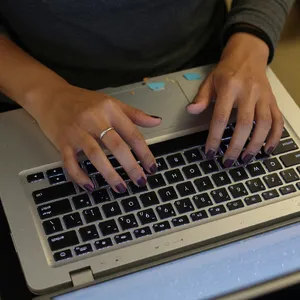 A person typing on a laptop keyboard, showing both hands on the keys. - XAI Grok Imagine (Quality)