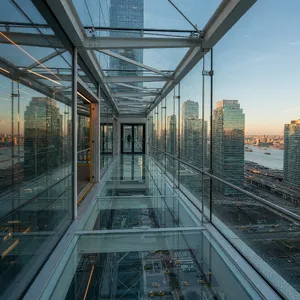 Photorealistic rendering of a contemporary glass skybridge between two skyscrapers, seen from inside with city views visible through glass walls and floor. Show accurate reflections and structural details. - XAI Grok Imagine (Quality)