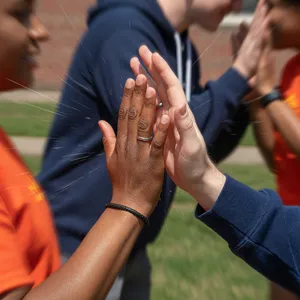 Two people high-fiving, with focus on their hands meeting mid-air. - XAI Grok Imagine (Quality)