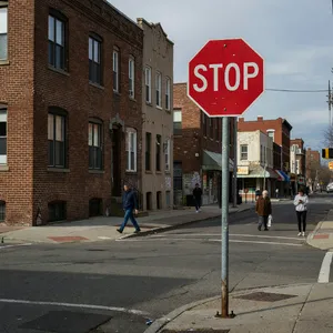 A red stop sign on a street corner displaying the word 