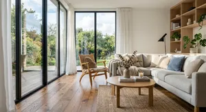 A photorealistic interior of a modern Scandinavian-style living room with natural light streaming through floor-to-ceiling windows. Show detailed wood textures, fabric materials, and proper light reflections. - Google Nano Banana 2