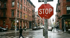 A red stop sign on a street corner displaying the word 