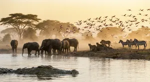A misty dawn at an African savanna watering hole where elephants, lions, and zebras coexist in tense harmony, with a crocodile partially submerged in the foreground and flamingos taking flight in the background, golden hour lighting. - Google Nano Banana Pro