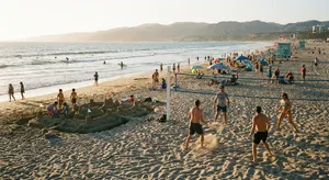 A beach scene: adults playing volleyball, kids building sandcastles, and surfers riding waves. - Google Nano Banana Pro