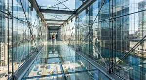 Photorealistic rendering of a contemporary glass skybridge between two skyscrapers, seen from inside with city views visible through glass walls and floor. Show accurate reflections and structural details. - Google Nano Banana Pro