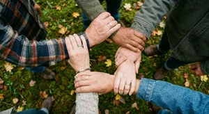 A group of five people joining hands in a circle, seen from above. - Google Nano Banana Pro