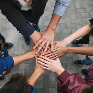 A group of five people joining hands in a circle, seen from above. - Black Forest Labs Flux 1.1 Pro Ultra