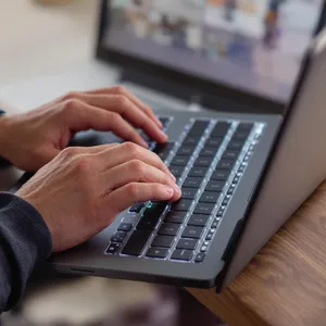 A person typing on a laptop keyboard, showing both hands on the keys. - Black Forest Labs Flux 1.1 Pro Ultra