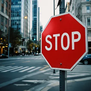 A red stop sign on a street corner displaying the word 