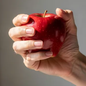 A realistic photo of a hand holding a red apple, with all fingers clearly visible. - Black Forest Labs FLUX.2 Max