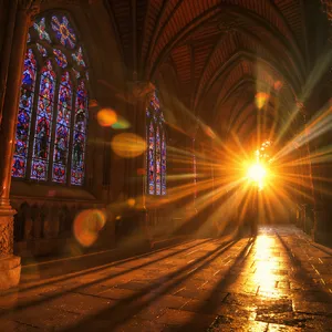 A Gothic cathedral interior at sunset with light streaming through detailed stained glass windows, creating colored patterns on stone floors and columns. Show accurate ribbed vaulting. - Black Forest Labs FLUX.1 Kontext Max