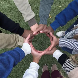 A group of five people joining hands in a circle, seen from above. - Black Forest Labs FLUX.1 Kontext Max