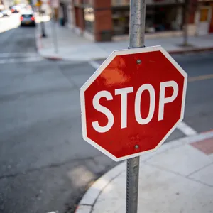 A red stop sign on a street corner displaying the word 