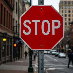 A red stop sign on a street corner displaying the word 