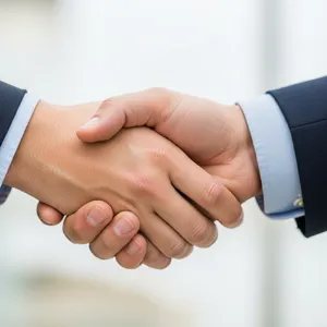 A close-up of two people shaking hands, both hands fully visible with five fingers each, in sharp focus against a blurred background. - Google Imagen 4.0 Ultra