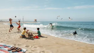 A beach scene: adults playing volleyball, kids building sandcastles, and surfers riding waves. - Ideogram Ideogram 4.0 (Quality)