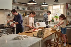 A family cooking together in a kitchen, each person busy with a different task. - Ideogram Ideogram 4.0 (Quality)