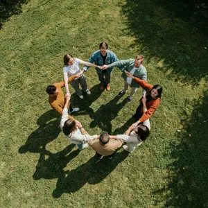 A group of five people joining hands in a circle, seen from above. - Ideogram Ideogram 4.0 (Quality)