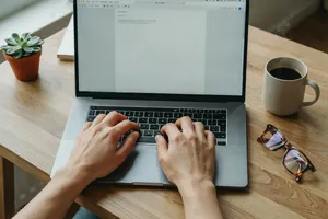 A person typing on a laptop keyboard, showing both hands on the keys. - Ideogram Ideogram 4.0 (Quality)