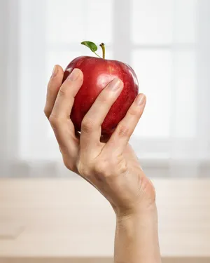 A realistic photo of a hand holding a red apple, with all fingers clearly visible. - Ideogram Ideogram 4.0 (Quality)