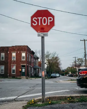 A red stop sign on a street corner displaying the word 