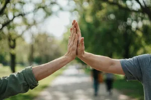 Two people high-fiving, with focus on their hands meeting mid-air. - Ideogram Ideogram 4.0 (Quality)