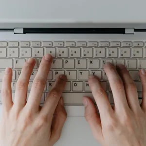 A person typing on a laptop keyboard, showing both hands on the keys. - Krea Krea 2 Large